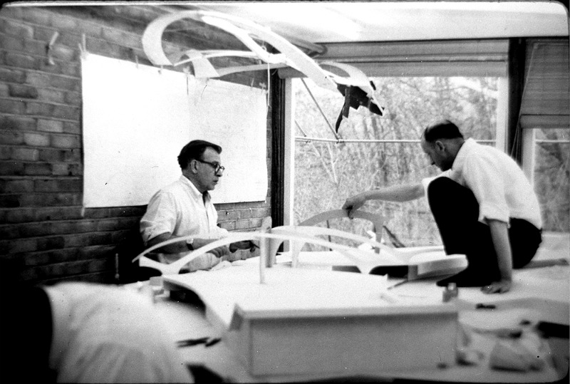 The photo of eero saarinen and kevin roche working on the twa terminal at idlewild airport (now jfk) is a powerful testament to their collaborative architectural genius in the late 1950s. Saarinen, a visionary in modern architecture, was commissioned by twa in 1955 to create a terminal that would embody the excitement of the jet age. His design, completed in 1962, features iconic sweeping concrete curves that evoke the sensation of flight. Kevin roche, a key associate in saarinen's firm, played a significant role in realizing this ambitious project. Their hands-on approach, evident in the photo, highlights their meticulous attention to detail and commitment to innovative design. The twa terminal, with its fluid interior spaces and groundbreaking structural elements, remains a landmark of modernist architecture and a symbol of mid-20th-century innovation.