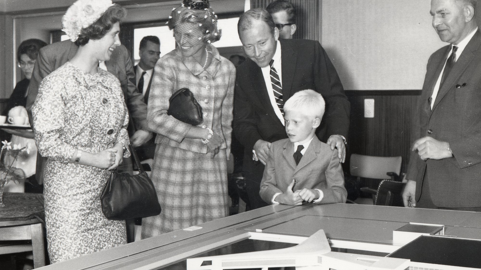 Sam johnson and his family examine an architectural model of europlant at the groundbreaking ceremony in 1963.