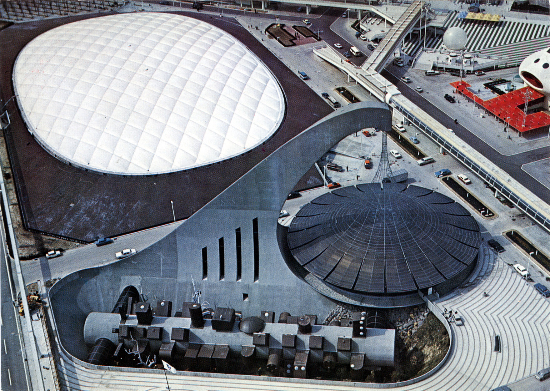 Usa pavilion and australia pavilion at expo ’70, osaka, 1970. “the us pavilion is covered with an air-supported roof consisting of a fiberglass fabric skin. The exhibition includes the latest achievements of apollo projects. From the shape of the australia pavilion’s giant cantilever, called ‘sky hook’, is suspended a circular free-hanging roof, sheltering a theater and the lobby. ”