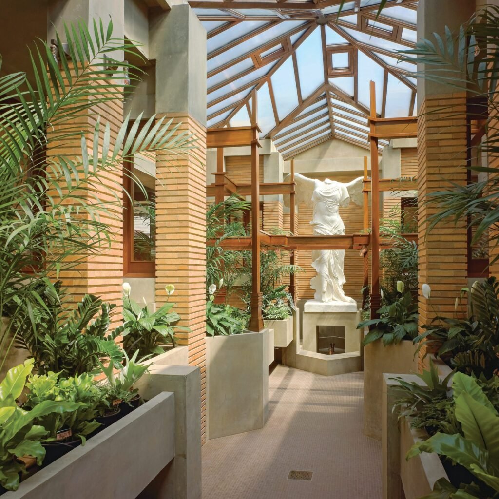 Interior view of the reconstructed conservatory, featuring a replica of the Nike of Samothrace statue to complete the setting. © Biff Henrich