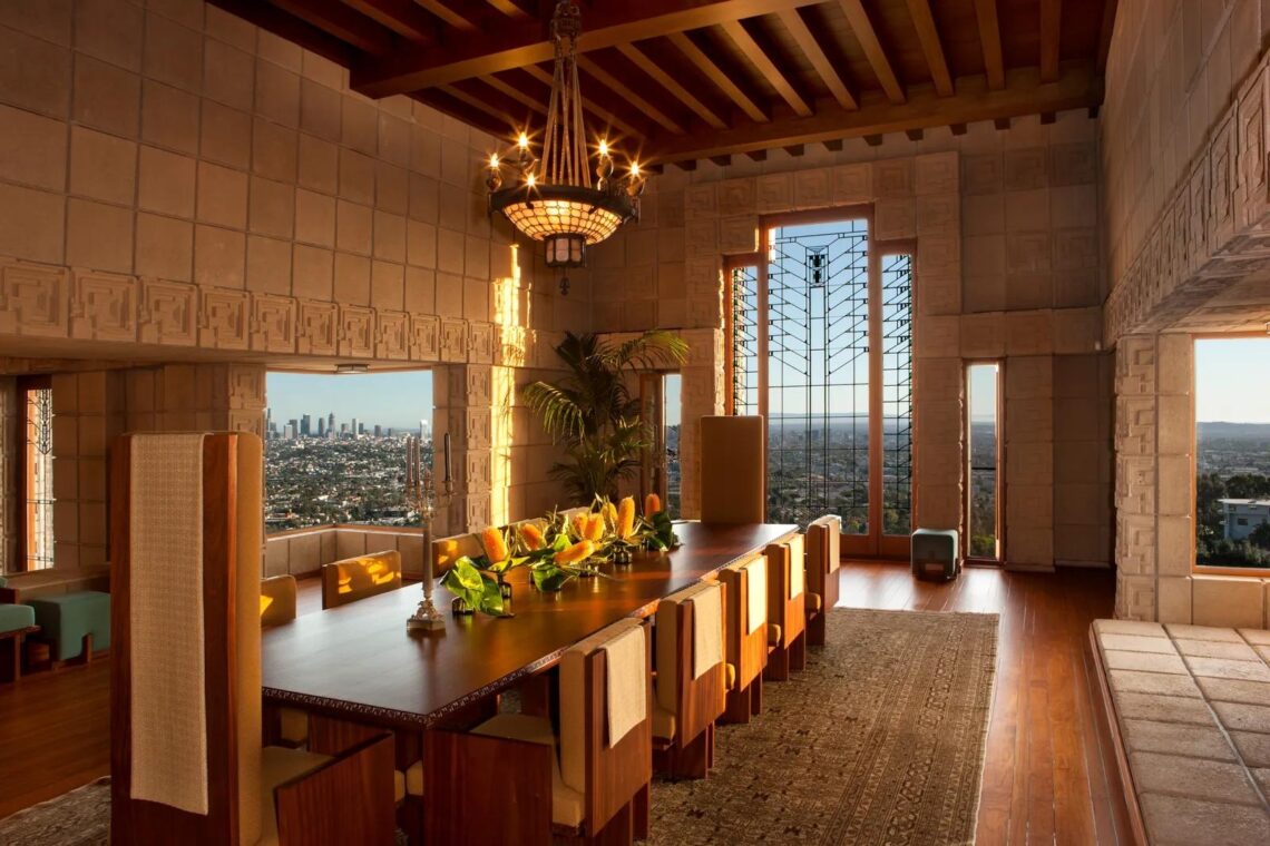 Dining room of ennis house with expansive views over los angeles and an art deco window. © architectural digest